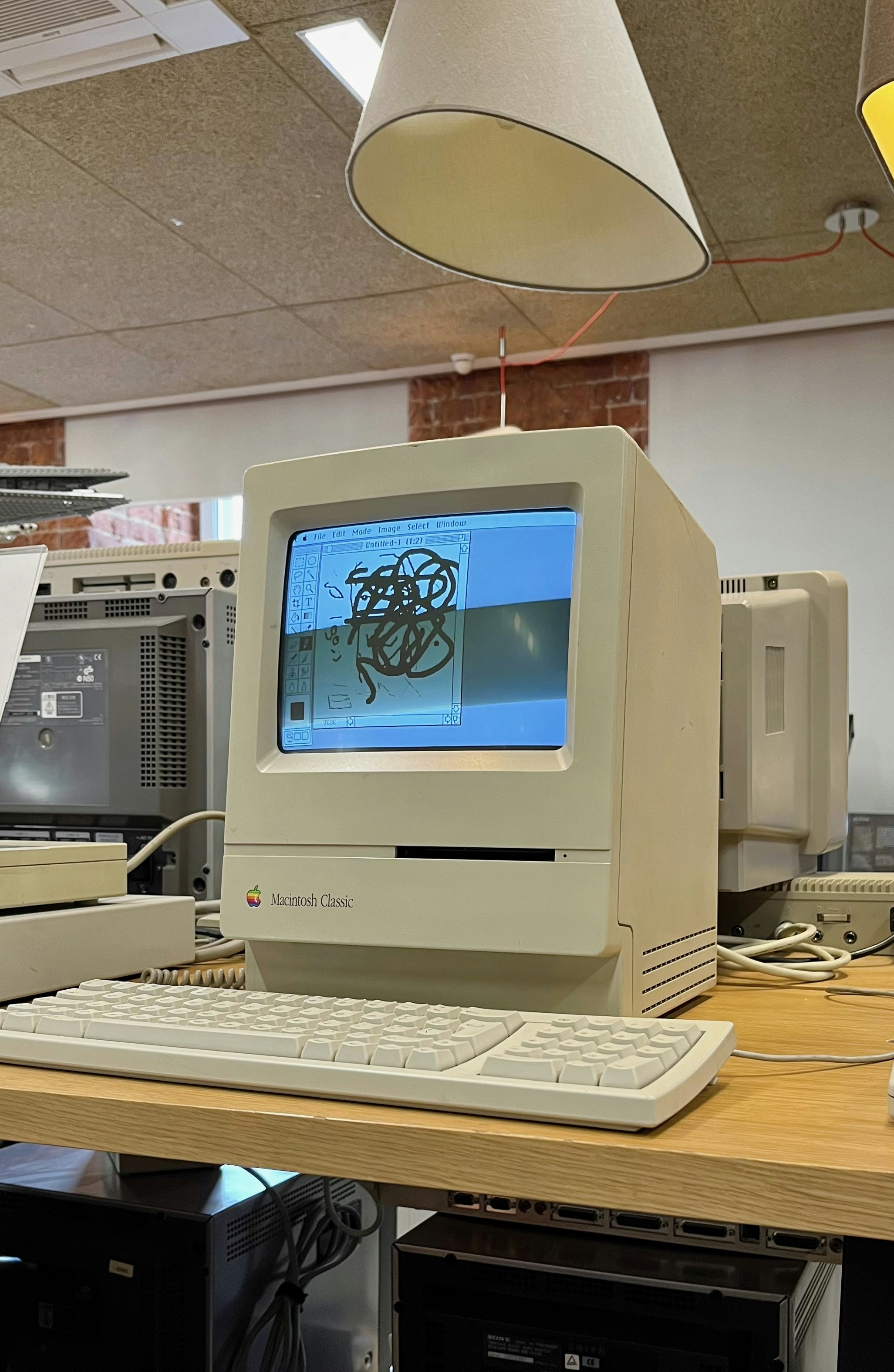 Macintosh Classic encendido en un espacio de colección